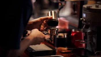 close-up-barista-making-cappuccino-bartender-preparing-coffee-drink_1150-14696